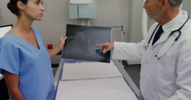 Χειρουργός και συνάδελφος συζητώντας πάνω από μια ακτινογραφία — Αρχείο Βίντεο