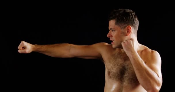 Mann boxt auf schwarzem Hintergrund — Stockvideo