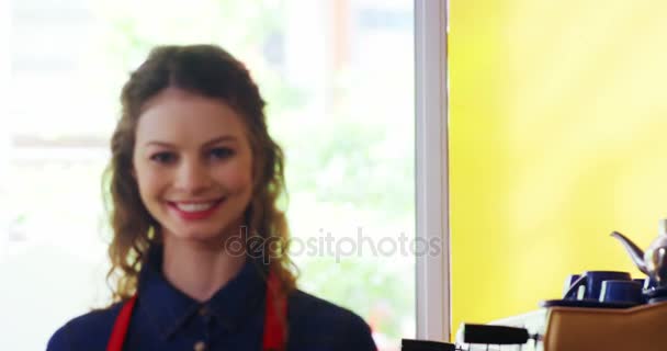 Усміхнена офіціантка стоїть за лічильником — стокове відео