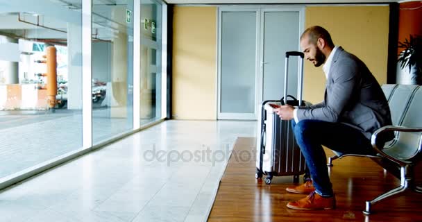 Zakenman texting op mobiele telefoon op luchthaven — Stockvideo