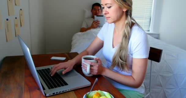 Mujer usando el ordenador portátil, mientras que el hombre usando tableta — Vídeo de stock