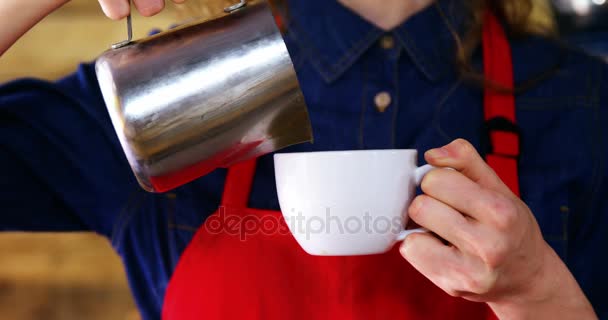 Camarera vertiendo leche en el café en el mostrador — Vídeos de Stock