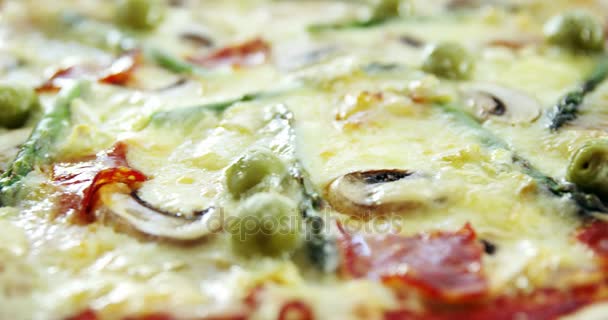 Deliciosa pizza italiana servida sobre mesa de madera — Vídeo de stock