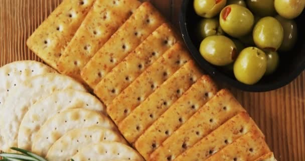 Cuenco de aceitunas verdes, especias, galletas crujientes, mermelada, hierba de romero, queso y nueces — Vídeos de Stock