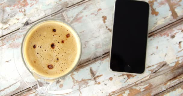 Чашка кофе и мобильный телефон — стоковое видео