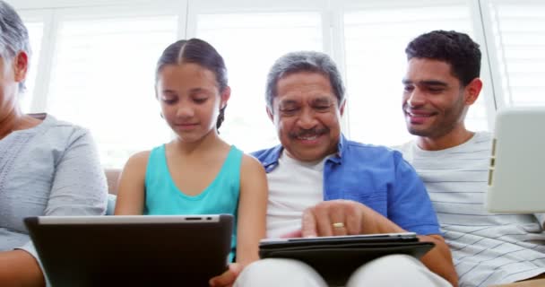 Familia feliz sentado en el sofá y el uso de ordenador portátil, teléfono móvil y tableta digital — Vídeos de Stock