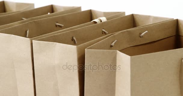 Beyaz arka plan üzerinde kahverengi alışveriş torbaları — Stok video