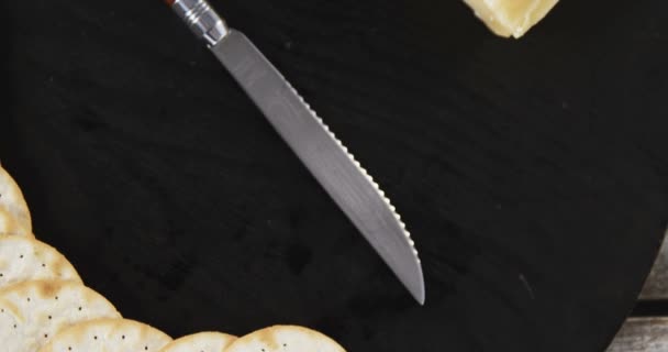 Scheibe Käse mit knusprigen Keksen und Messer — Stockvideo