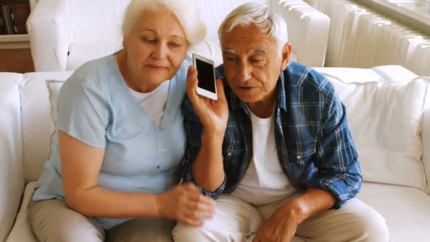 Старшая пара разговаривает по мобильному телефону — стоковое видео