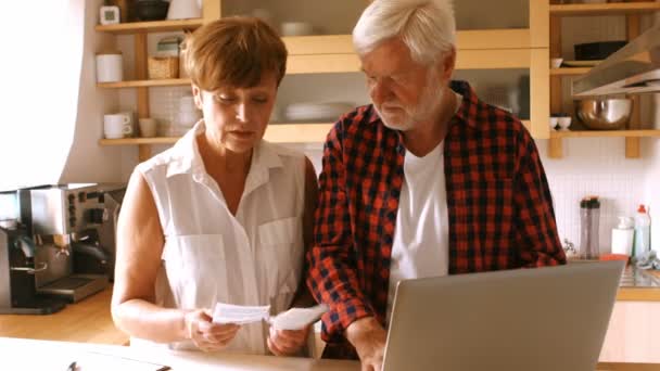 Para starszych płacąc rachunki przez Internet na laptopie — Wideo stockowe