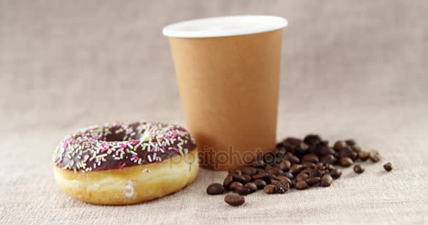 Одноразовая чашка кофе и шоколадный пончик — стоковое видео