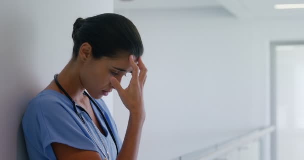 Sad female surgeon standing in corridor — Stock Video