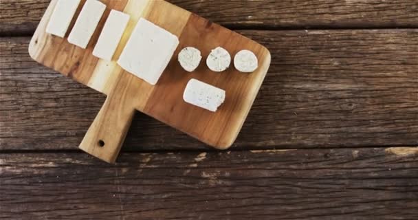Кусочки сыра на деревянной доске — стоковое видео
