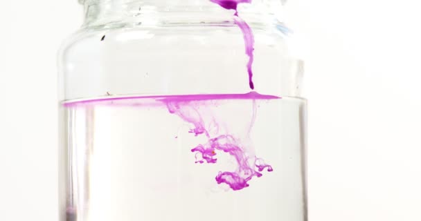 Roze kleur vloeistof verspreiden in water — Stockvideo