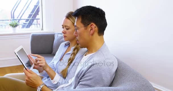 Casal usando tablet enquanto relaxa no sofá — Vídeo de Stock