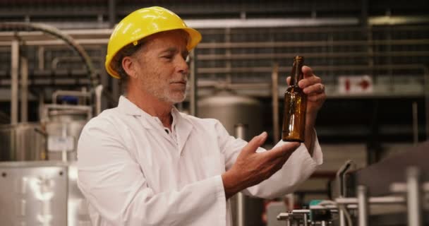 Trabajador de fábrica inspeccionando una botella de vidrio — Vídeos de Stock