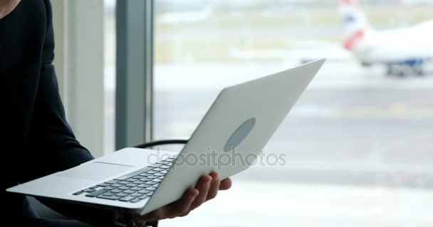 Uomo d'affari guardando il computer portatile in aeroporto — Video Stock