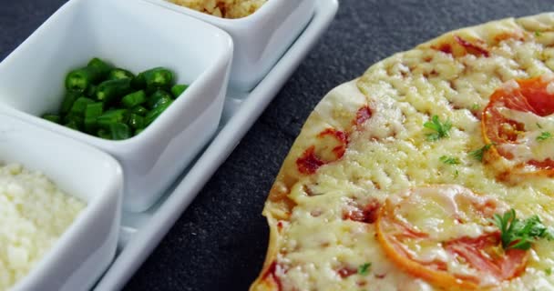 Gebakken pizza met cherry tomaat toppings en ingrediënten — Stockvideo