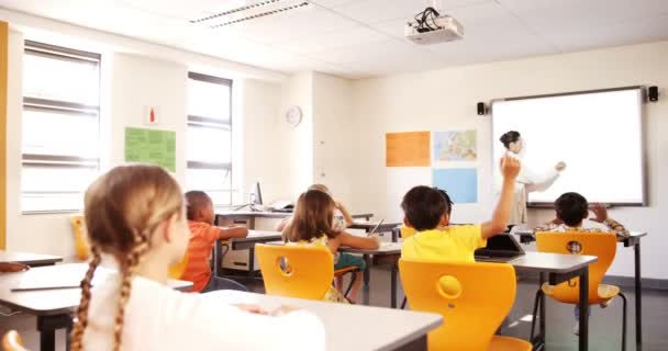 Crianças da escola levantando a mão na sala de aula — Vídeo de Stock