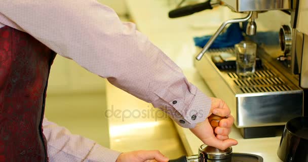 Cameriere utilizzando un manomissione per premere il caffè macinato — Video Stock