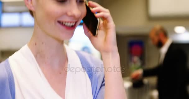 Hermosa mujer hablando en el teléfono móvil en la zona de espera — Vídeo de stock