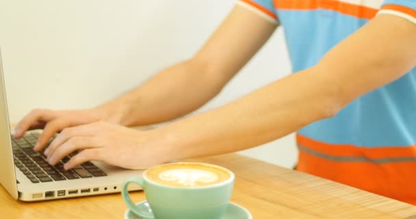 Человек с ноутбуком во время питья кофе — стоковое видео