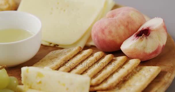 Diferentes tipos de queijo com biscoitos crocantes, frutas e molho — Vídeo de Stock