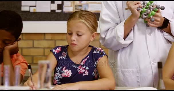 Teacher assisting school kids with molecule model — Stock Video