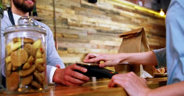 Woman paying bill through smartphone using NFC technology — Stock Video