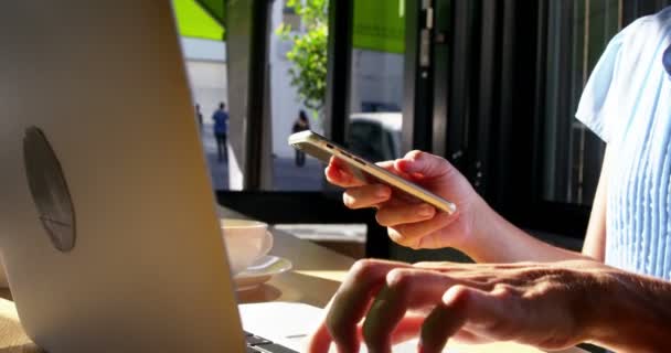 Бизнесмен с помощью телефона и ноутбука — стоковое видео