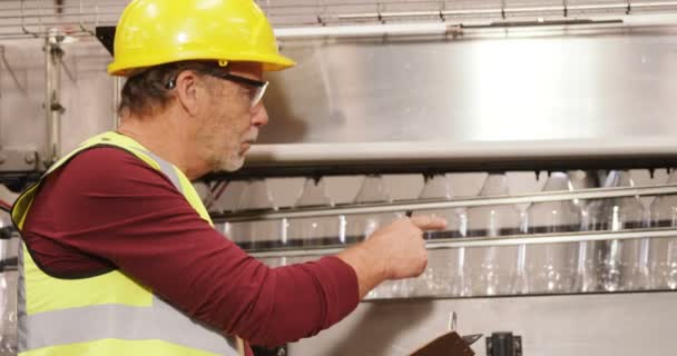 Travailleur vérifiant bouteilles sur la ligne de production — Video