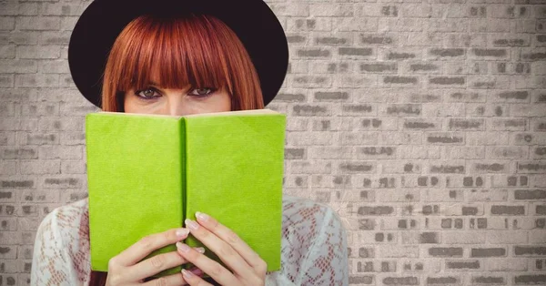 Vrouw met groene boek tegen muur — Stockfoto