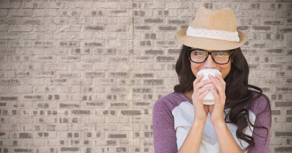 Sammansatt bild av kvinna med kaffe mot tegelvägg — Stockfoto