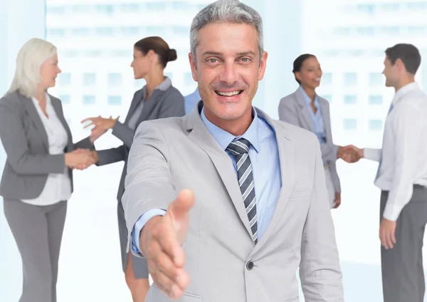 Handshake in front of business people in office — Stock Photo, Image