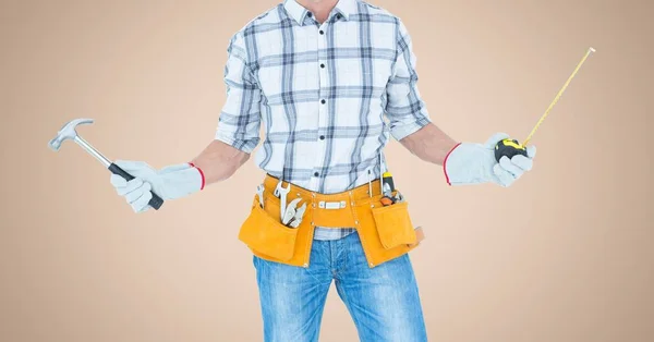Carpenter with hammer and measuring tape against cream background — Stock Photo, Image