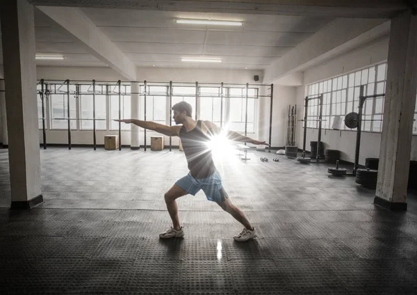 Man stretching in gym with flare — Stock Photo, Image