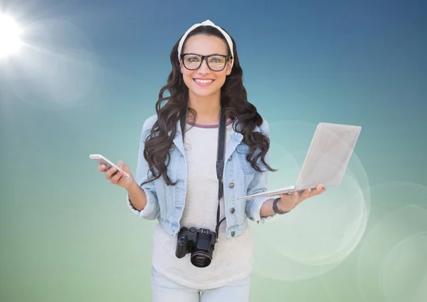 Kvinna med telefon och laptop mot blå grön bakgrund med flare — Stockfoto