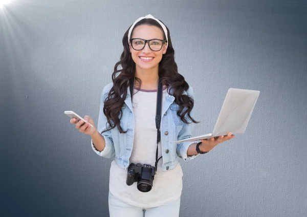 Kvinna med telefon, laptop och kamera mot marinblå bakgrund med flare — Stockfoto