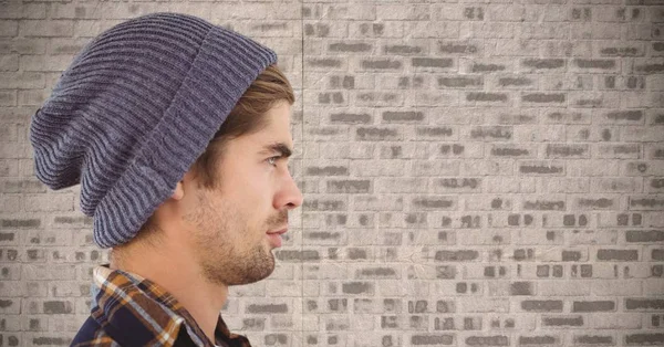 Imagem composta de Homem com gorro contra parede de tijolo — Fotografia de Stock