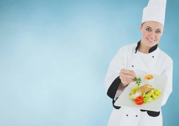 Chef-kok met plaat van voedsel tegen blauwe achtergrond — Stockfoto