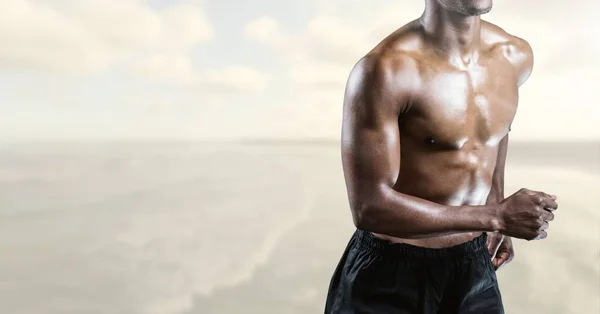Composietbeeld van man Fitness Torso tegen zee op achtergrond — Stockfoto