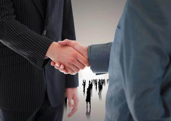 Handshake před silueta podnikatelů — Stock fotografie