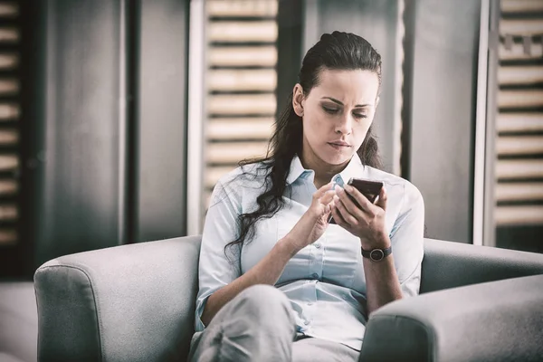 Mujer de negocios sentada y usando teléfono móvil —  Fotos de Stock