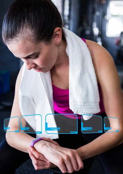 Frau sieht Fitnessband am Handgelenk im Fitnessstudio — Stockfoto