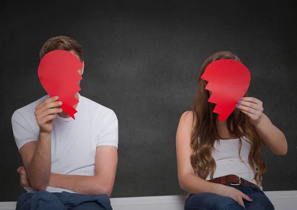 Depressed couple holding broken heart against grey background — Stock Photo, Image