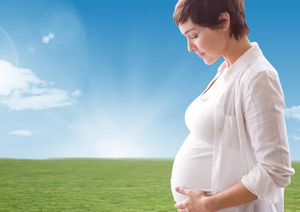 Pregnant woman looking a her belly — Stock Photo, Image