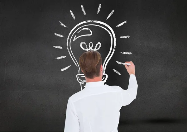 Man drawing a light bulb on blackboard — Stock Photo, Image