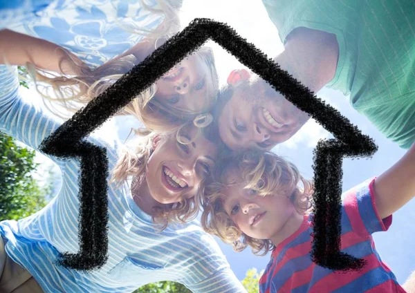 Familjen kramar varandra mot hus disposition i bakgrunden — Stockfoto