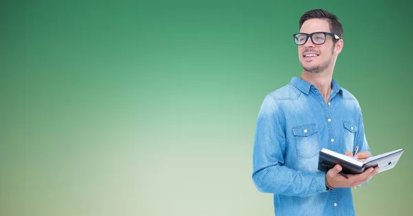 Un homme souriant écrit sur un carnet — Photo