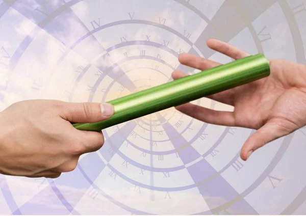 Athletes passing the baton during relay race against digitally generated clock — Stock Photo, Image